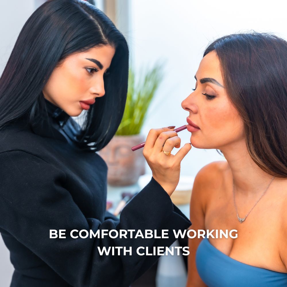 Young lady with black hair applying lip liner on another young lady