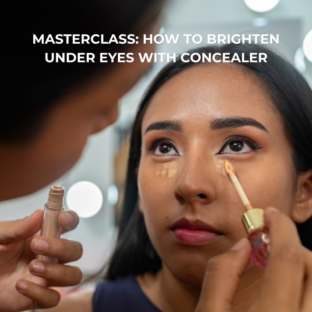 Makeup artist applying concealer under ladies eyes